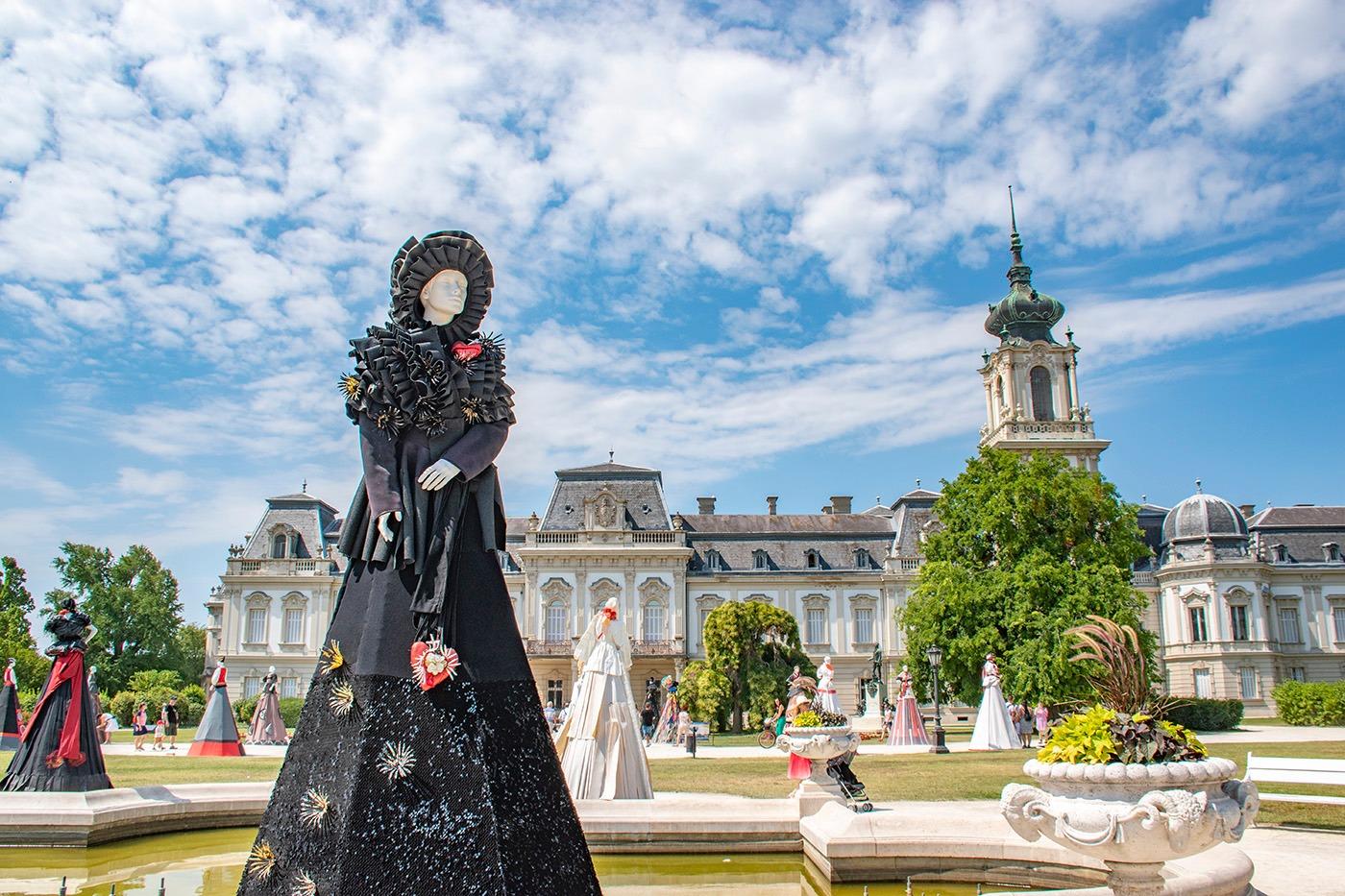Óriásbábok tartanak divatbemutatót a keszthelyi kastélyparkban